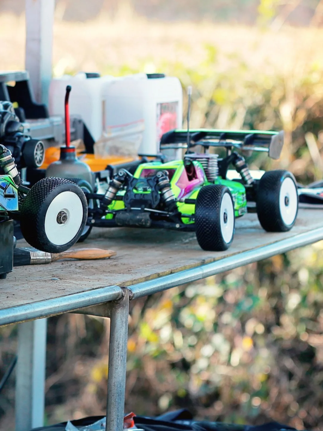 Zdalnie sterowane modele samochodów RC typu buggy ustawione na stole w plenerze